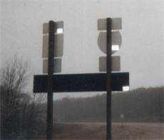 Sign cluster with triad"tacmarks" found just prior to Camp Grayling Military Reserve *checkpoint*.